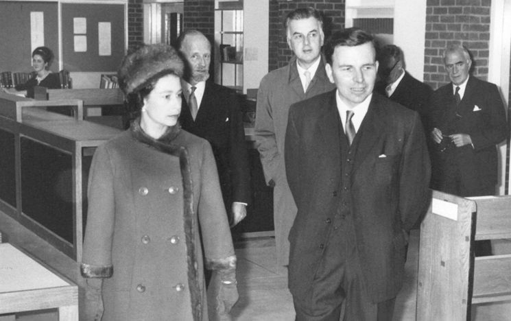 Black and white photograph of founding Librarian Dennis Cox shows the Queen around the Library on her visit to campus in November 1964 to open the new Library building.