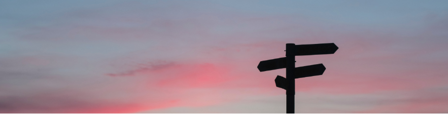 Signpost against a sunset