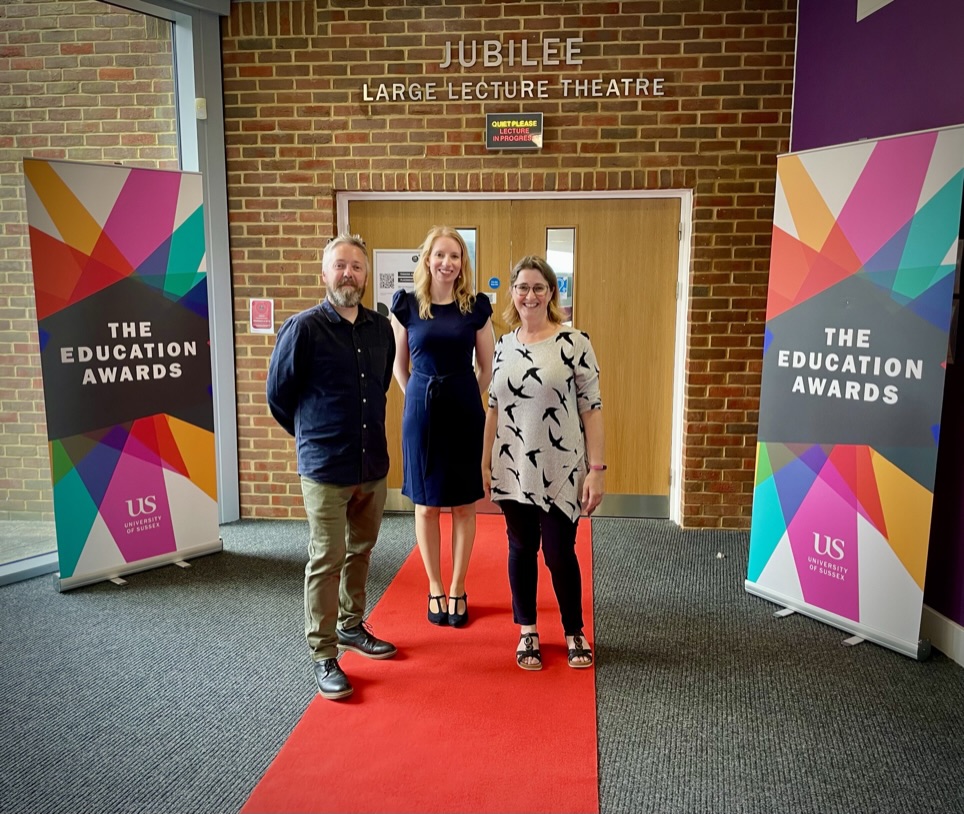 Dan Axson, Katie Turner and Katie Piatt stand in front of banners saying 'The Education Awards'.