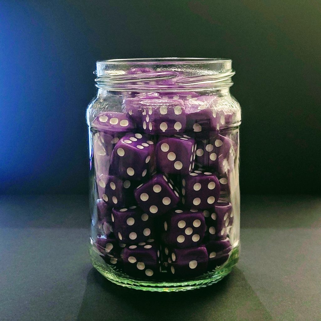 A glass jar filled with purple dice.